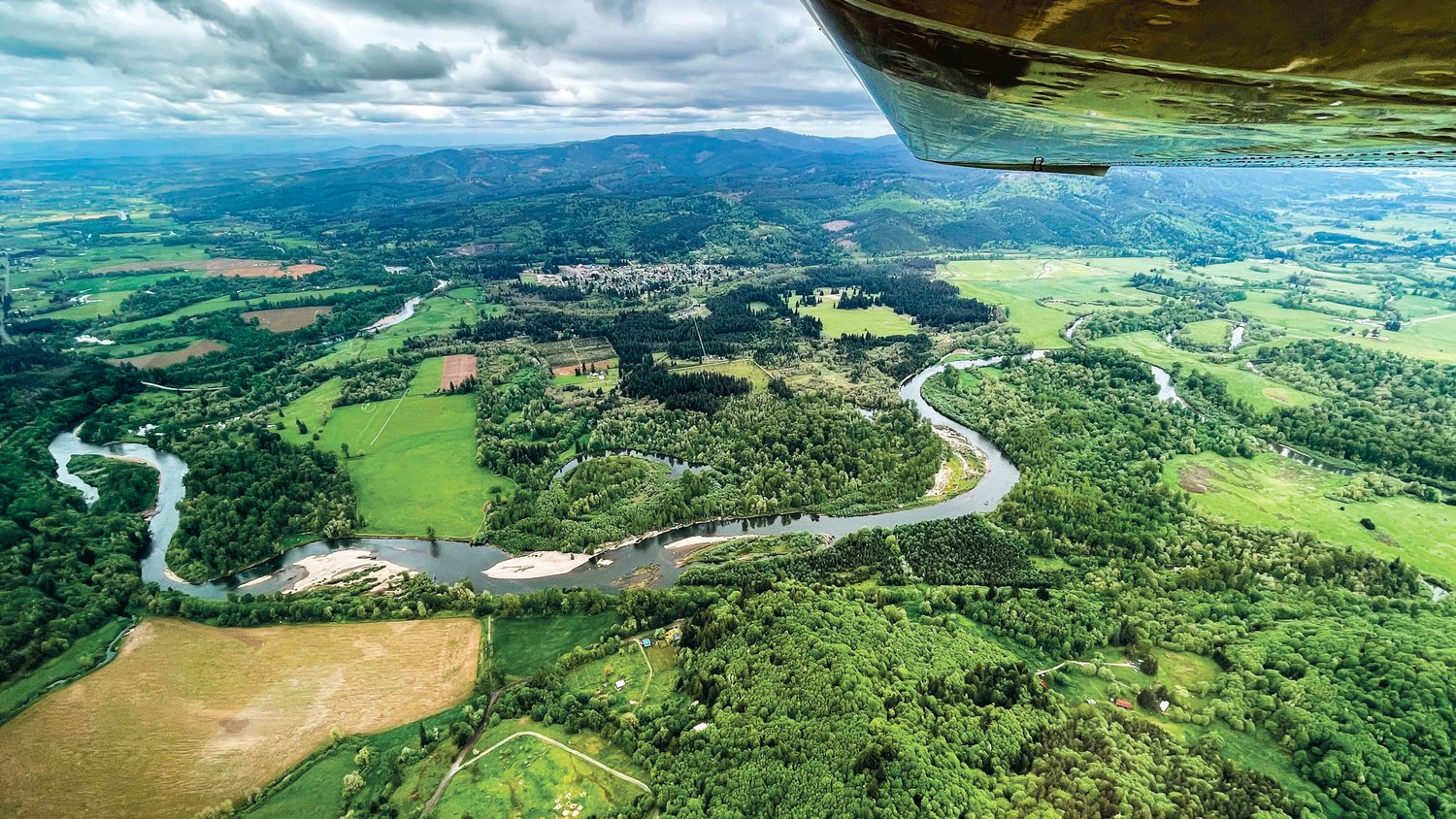 The Chehalis River flows through forests and farmland south of the town of Oakville, which can be seen at the center top of this photograph.